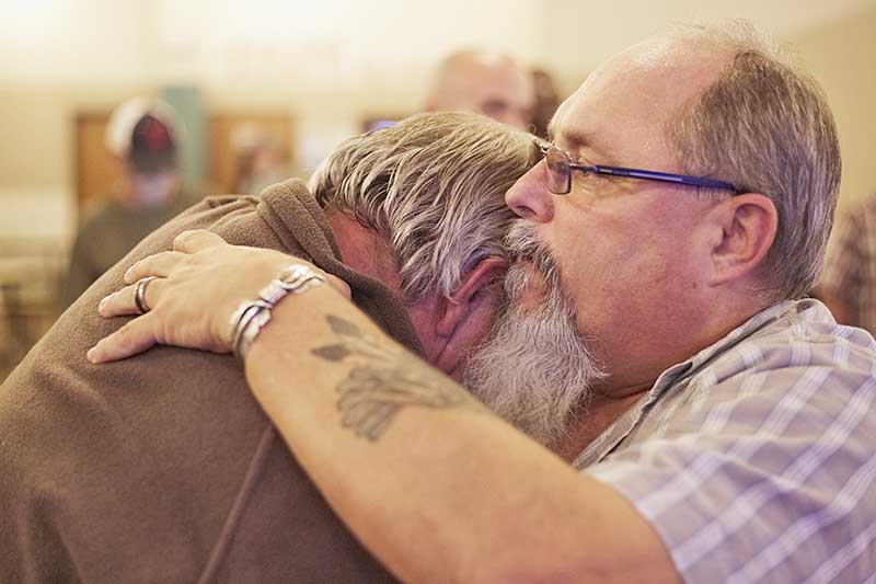 Pastor Larry praying with homeless man