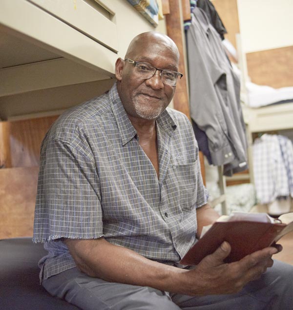 Homeless man reading at rescue mission